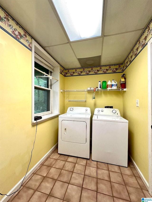 laundry area with separate washer and dryer and light tile patterned floors