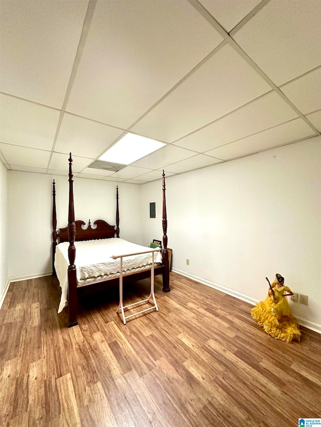 bedroom with hardwood / wood-style flooring and a paneled ceiling