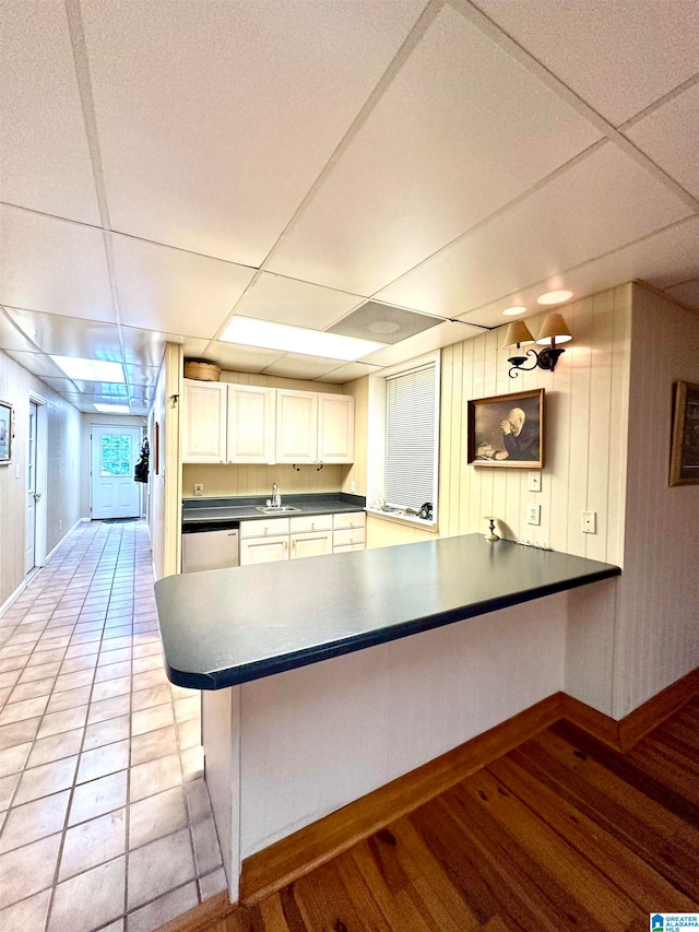 kitchen featuring a drop ceiling, light wood-type flooring, and kitchen peninsula