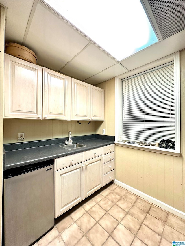 kitchen featuring light tile patterned flooring, sink, and stainless steel dishwasher