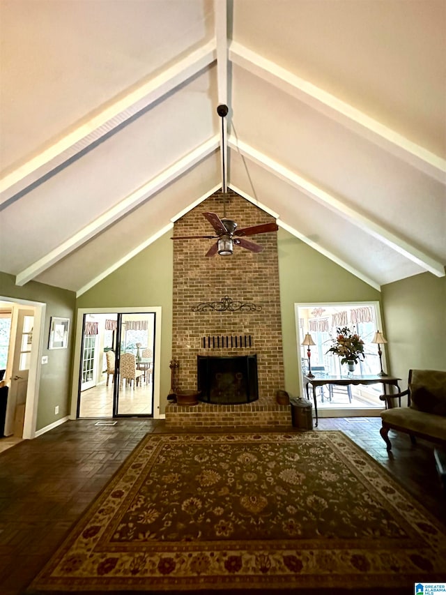 living room featuring brick wall, a brick fireplace, lofted ceiling with beams, and ceiling fan