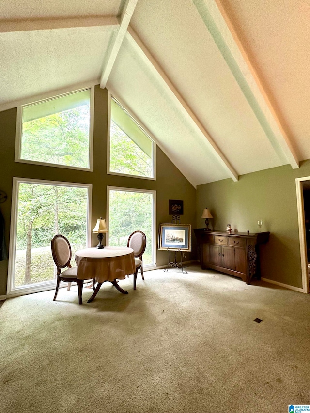 carpeted dining area with plenty of natural light, lofted ceiling with beams, and a textured ceiling