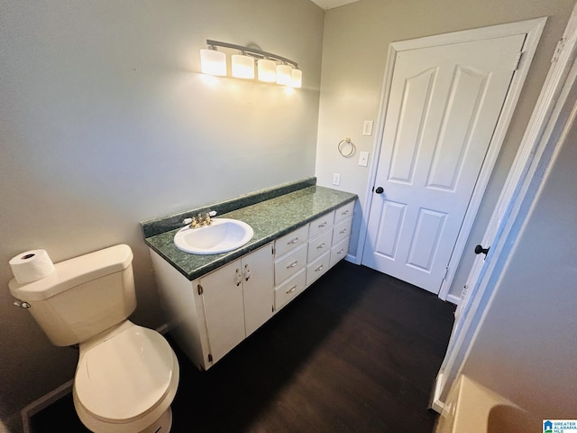 bathroom featuring vanity, toilet, and wood finished floors