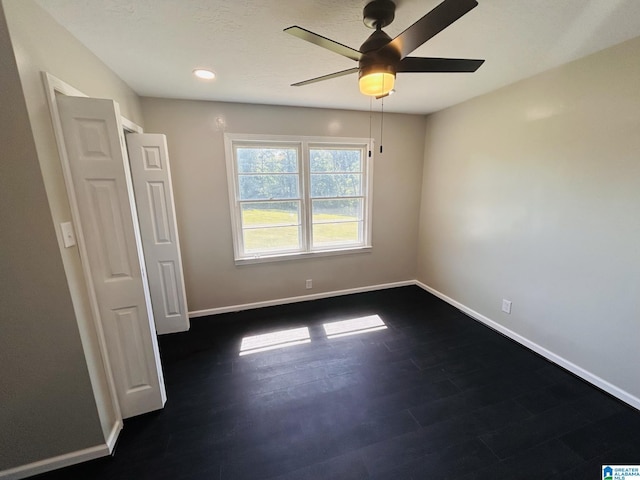 empty room featuring dark wood-style floors, recessed lighting, a ceiling fan, and baseboards