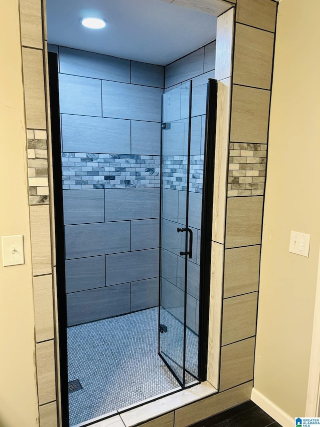 bathroom featuring baseboards and a stall shower