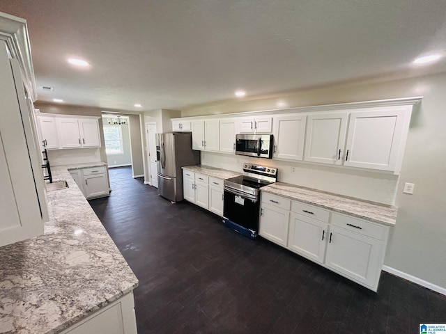 kitchen featuring baseboards, dark wood finished floors, recessed lighting, stainless steel appliances, and white cabinetry