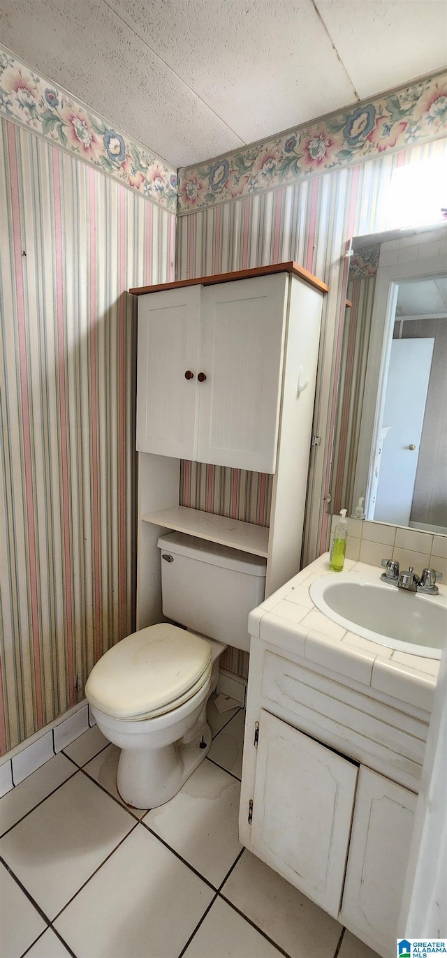 bathroom featuring vanity, tile patterned floors, and toilet