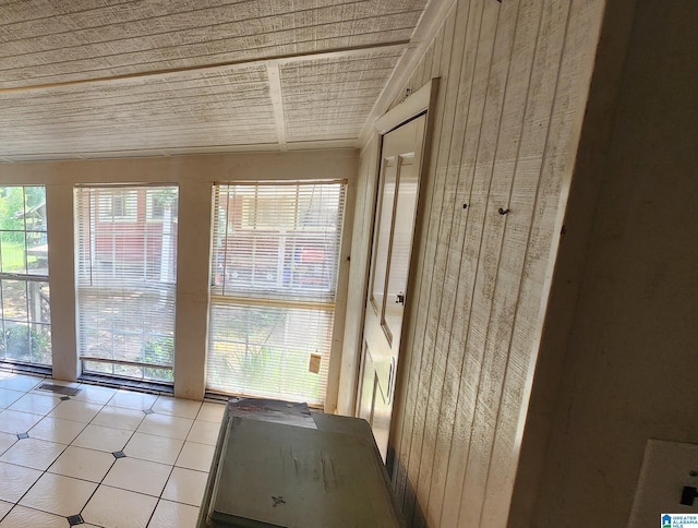 doorway featuring light tile patterned floors, wooden walls, and wooden ceiling