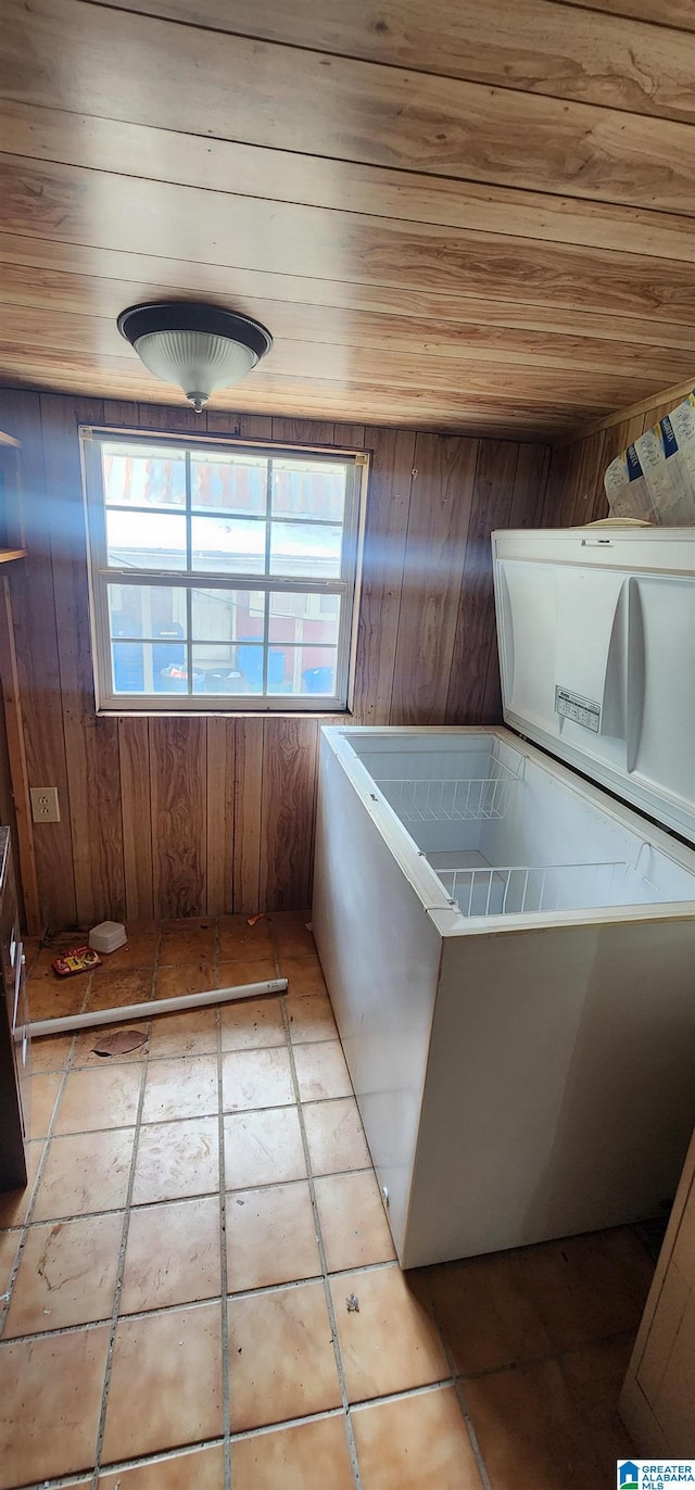 clothes washing area featuring wood walls, light tile patterned floors, and wooden ceiling