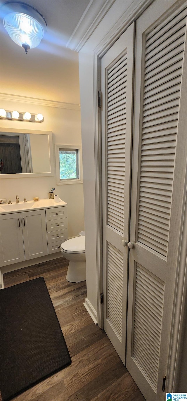 bathroom featuring ornamental molding, vanity, toilet, and hardwood / wood-style floors