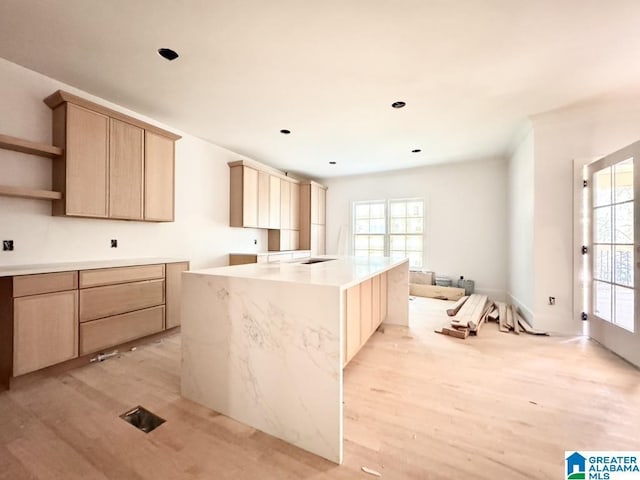 kitchen with light hardwood / wood-style flooring, light brown cabinetry, and a center island