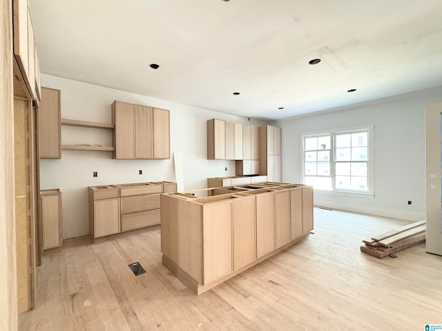 kitchen with ornamental molding, light brown cabinetry, and light hardwood / wood-style flooring