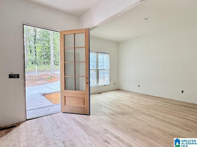 entryway with a healthy amount of sunlight, light wood-type flooring, and french doors