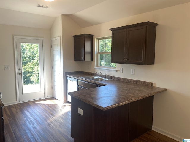 kitchen with a sink, visible vents, dark brown cabinets, stainless steel dishwasher, and dark countertops