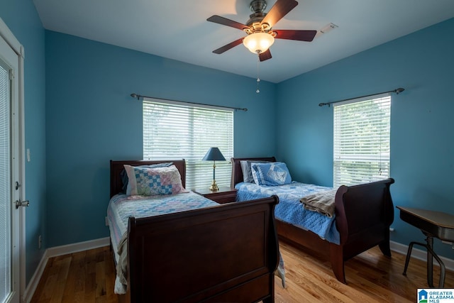 bedroom with ceiling fan, light hardwood / wood-style floors, and multiple windows