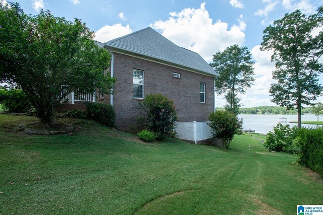 view of side of property featuring a water view and a lawn