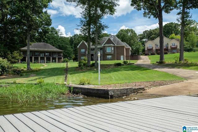 view of dock with a water view and a yard