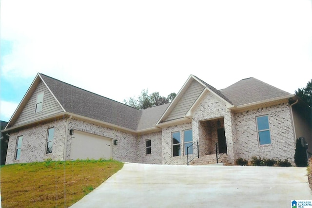 craftsman house with brick siding, driveway, and a front lawn