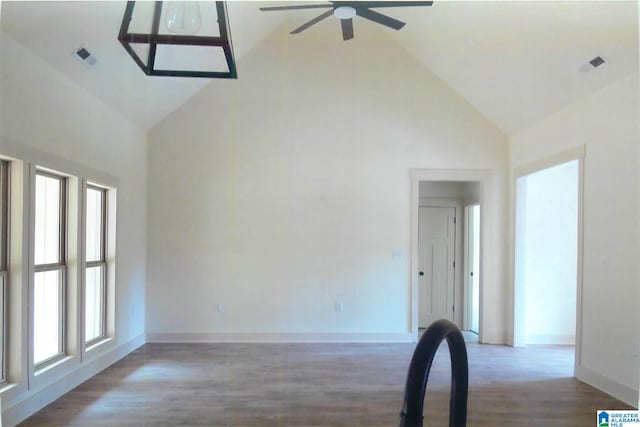 unfurnished room featuring hardwood / wood-style flooring, ceiling fan, a healthy amount of sunlight, and high vaulted ceiling