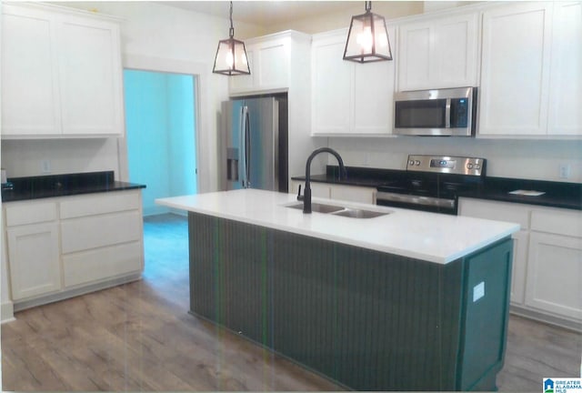 kitchen featuring appliances with stainless steel finishes, hardwood / wood-style flooring, and decorative light fixtures