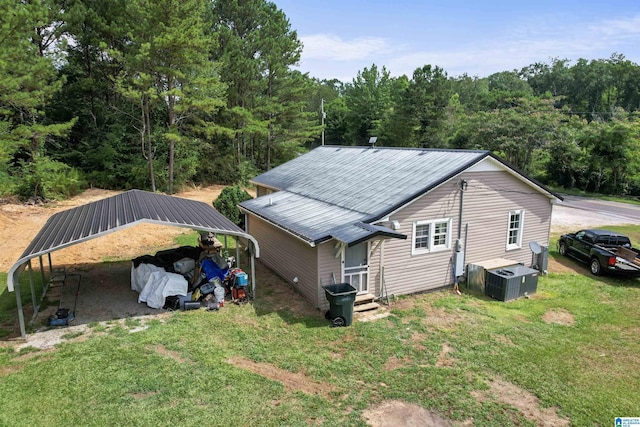 rear view of house featuring a lawn and a carport