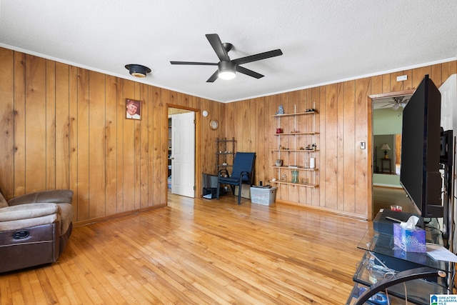 sitting room featuring hardwood / wood-style flooring, crown molding, a textured ceiling, and ceiling fan