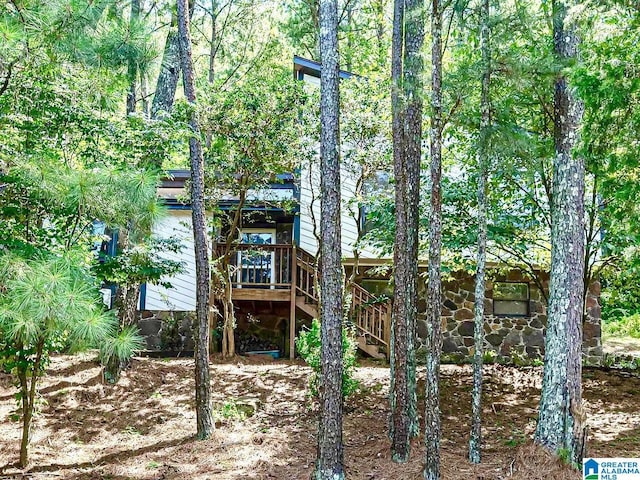 rear view of property featuring a wooden deck and stairs