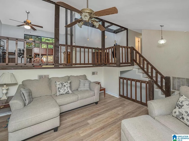 living room featuring stairway, wood finished floors, visible vents, and ceiling fan