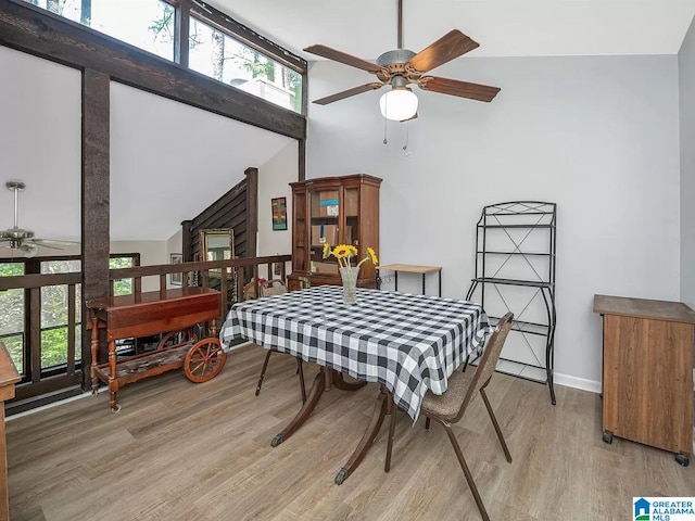 dining room with plenty of natural light, high vaulted ceiling, ceiling fan, and light wood finished floors