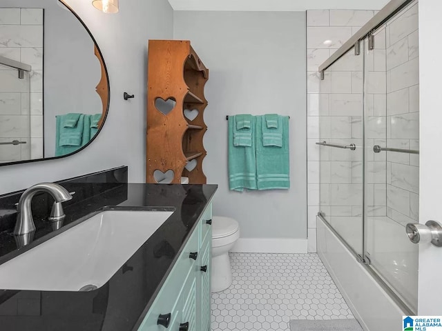 bathroom with toilet, vanity, baseboards, and shower / bath combination with glass door
