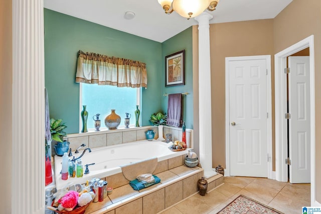 bathroom with tile patterned flooring, a relaxing tiled tub, and decorative columns