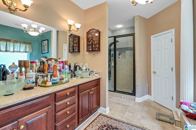 bathroom featuring decorative columns, vanity, an enclosed shower, and tile patterned floors