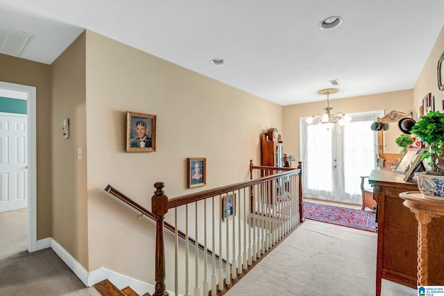 hall featuring an inviting chandelier and carpet