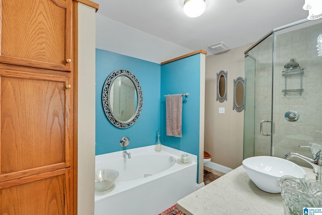 full bathroom featuring vanity, shower with separate bathtub, and toilet