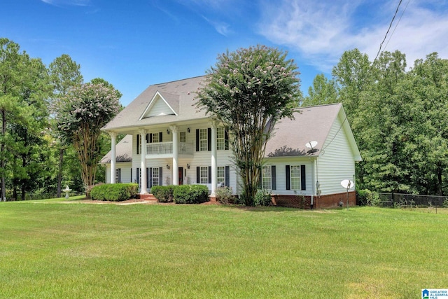 view of front of house featuring a balcony and a front yard