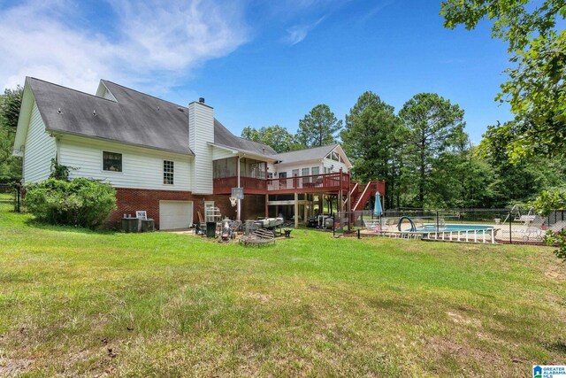 back of house with a pool side deck, a yard, and a garage