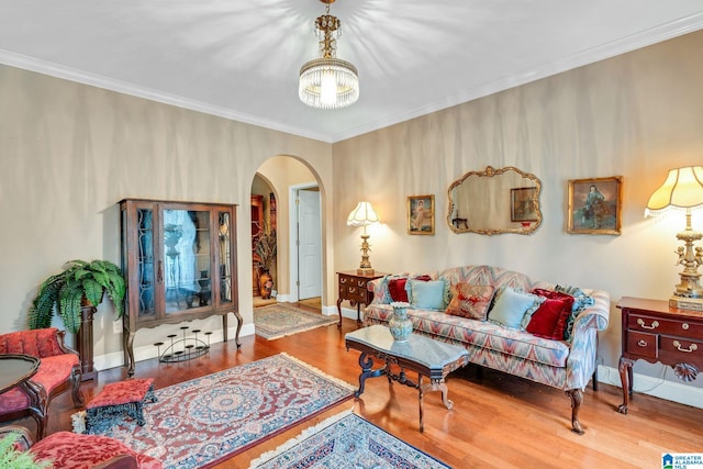 living room with ornamental molding, hardwood / wood-style floors, and a chandelier