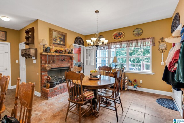 dining space with tile patterned floors, a notable chandelier, and a fireplace