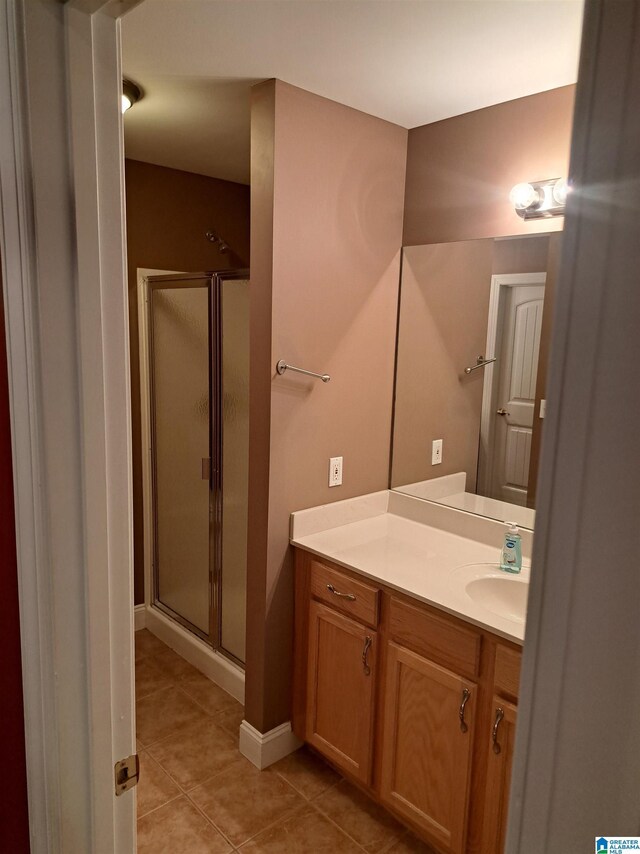 full bath with tile patterned flooring, a shower stall, and vanity