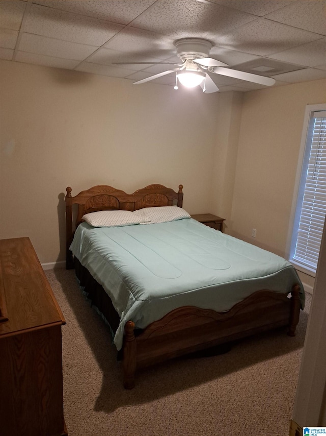 bedroom featuring carpet floors, a ceiling fan, a drop ceiling, and baseboards