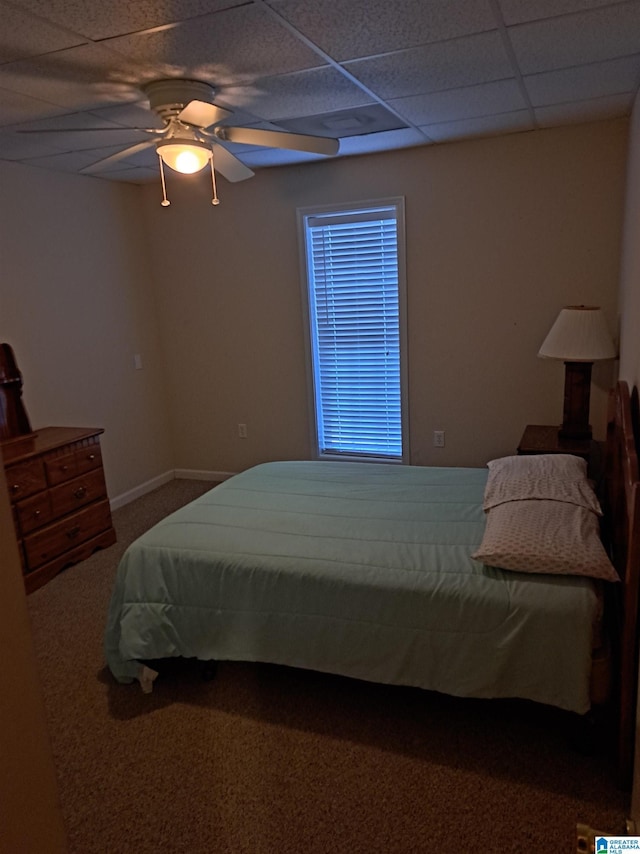 carpeted bedroom with a paneled ceiling and a ceiling fan