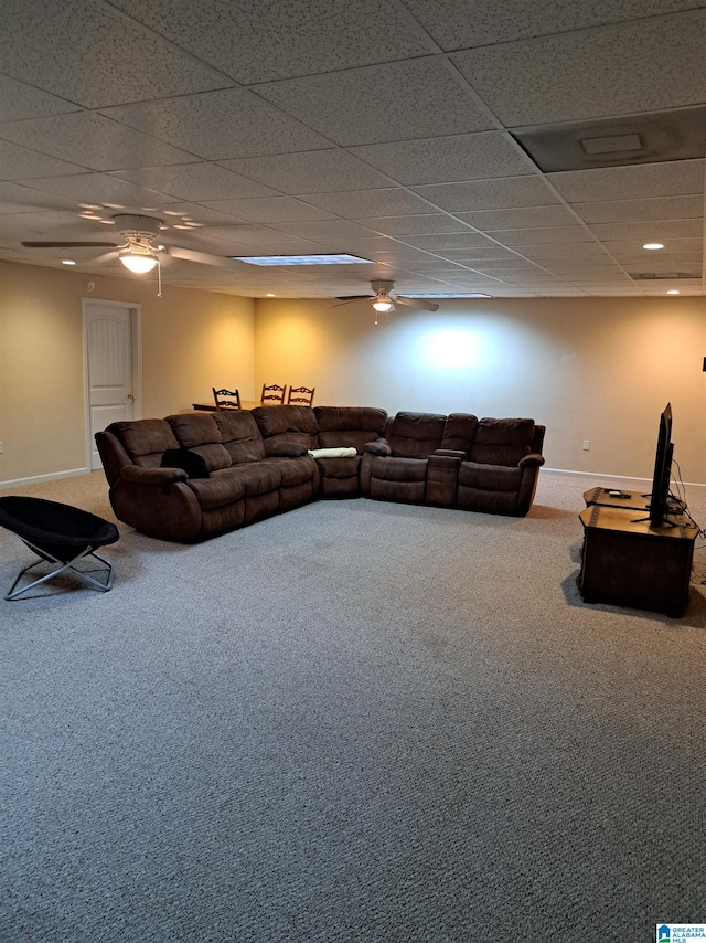 living area with carpet, a ceiling fan, baseboards, and a drop ceiling