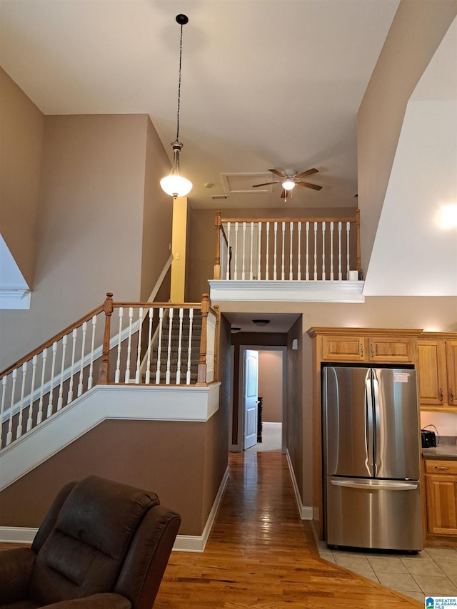 kitchen with freestanding refrigerator, a ceiling fan, light wood-type flooring, hanging light fixtures, and baseboards