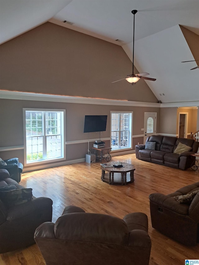 living area featuring a ceiling fan, wood finished floors, and high vaulted ceiling