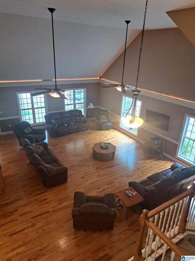 living room featuring ceiling fan, wood finished floors, healthy amount of natural light, and high vaulted ceiling