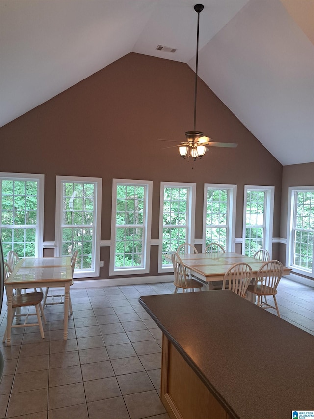 dining room with high vaulted ceiling, ceiling fan, and light tile patterned floors