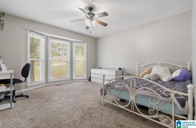 bedroom featuring ceiling fan, a textured ceiling, and carpet flooring