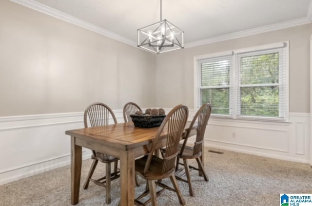 dining area featuring crown molding, light carpet, and a chandelier