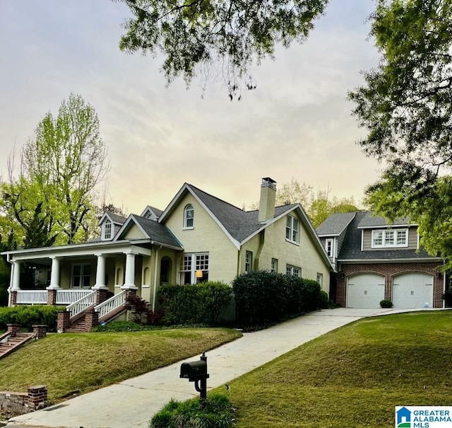 view of front of property with a yard, a garage, and covered porch