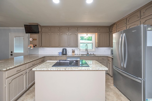 kitchen featuring ornamental molding, a peninsula, freestanding refrigerator, decorative backsplash, and a sink
